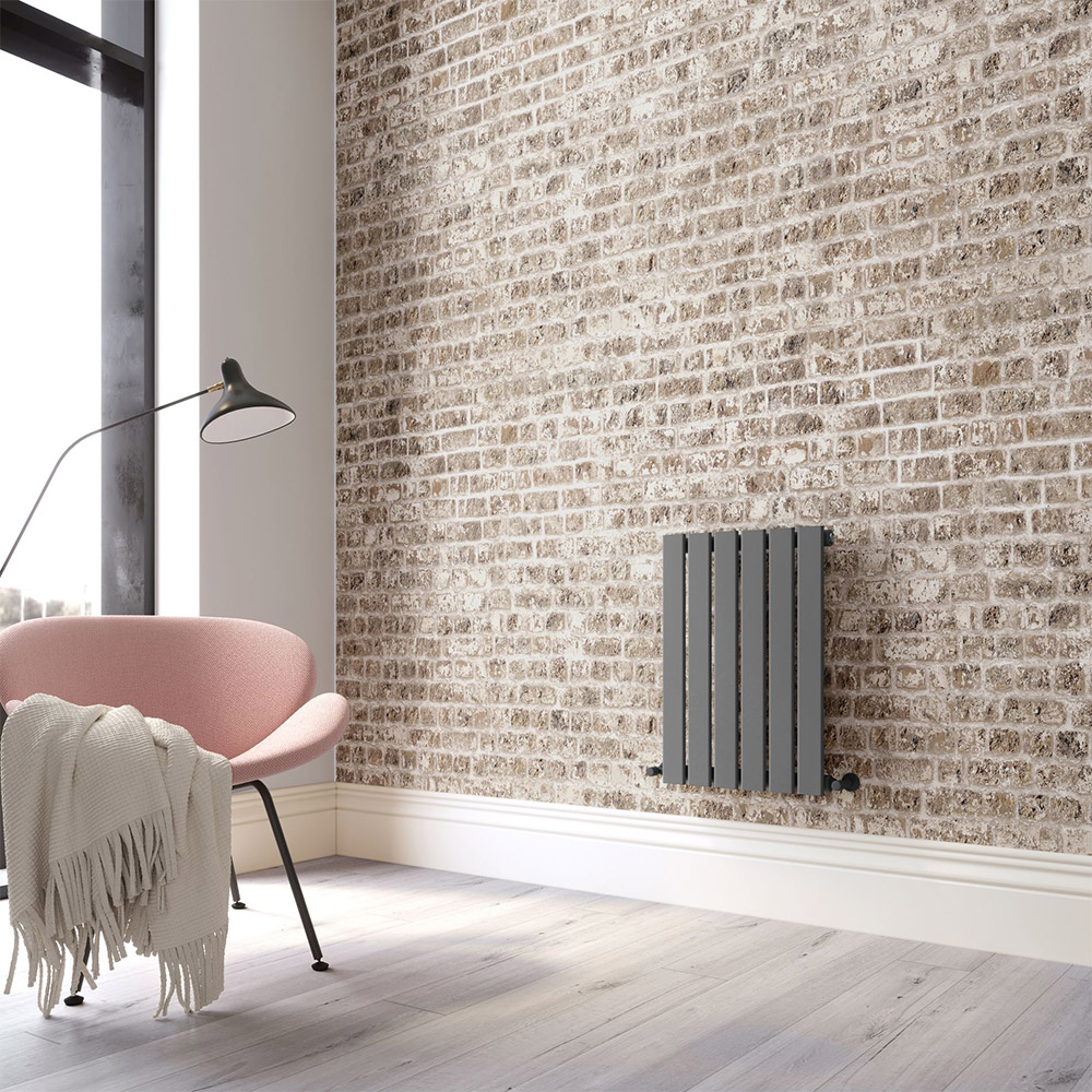 small grey radiator against a brick wall