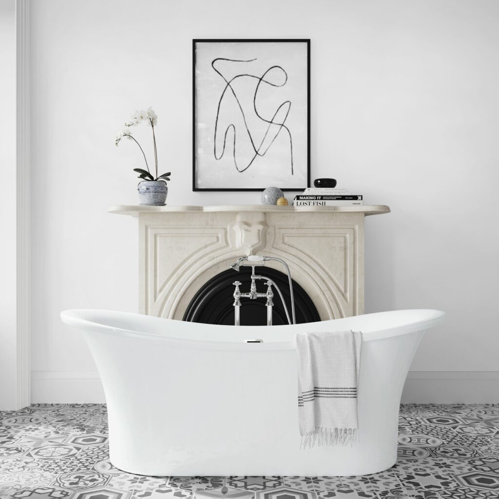 freestanding white acrylic roll top slipper bath in front of a disused fireplace in a bathroom