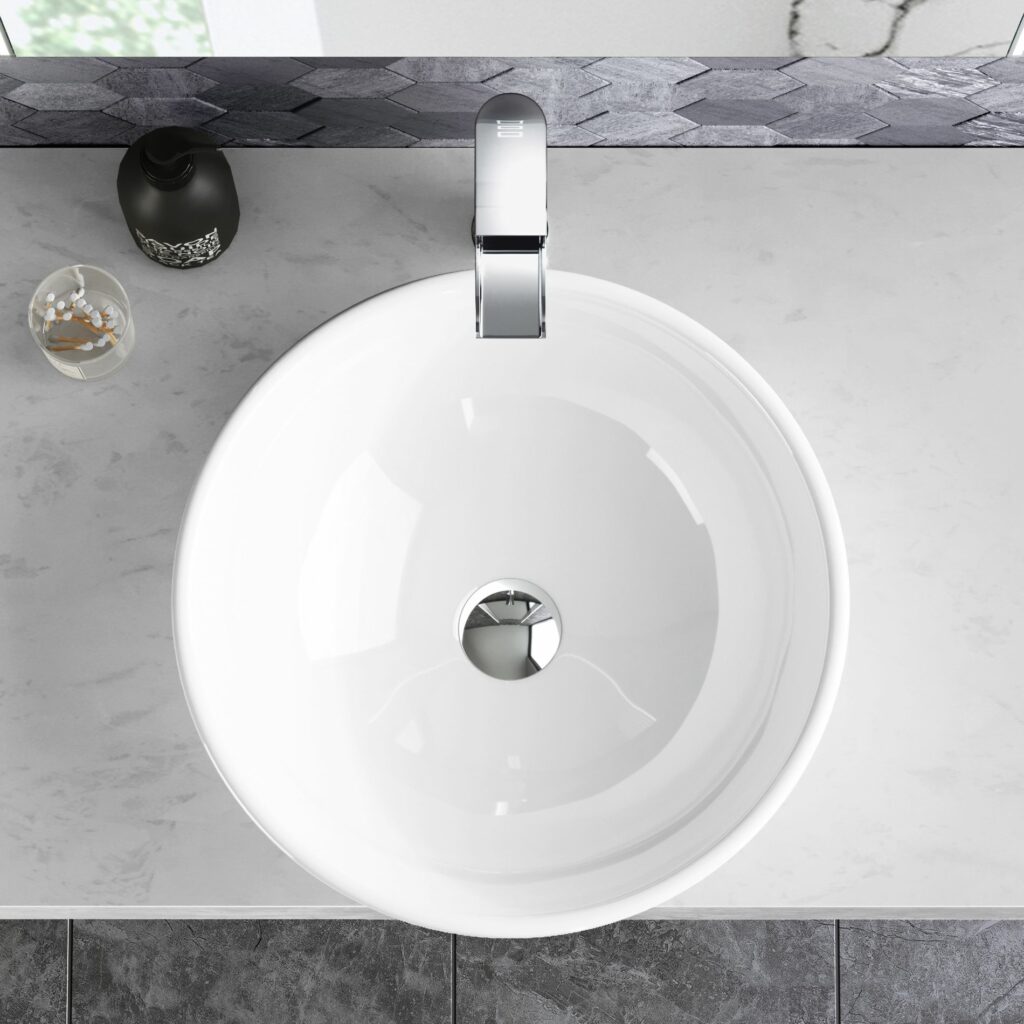 white basin with chrome tap and plug on a marble counter top