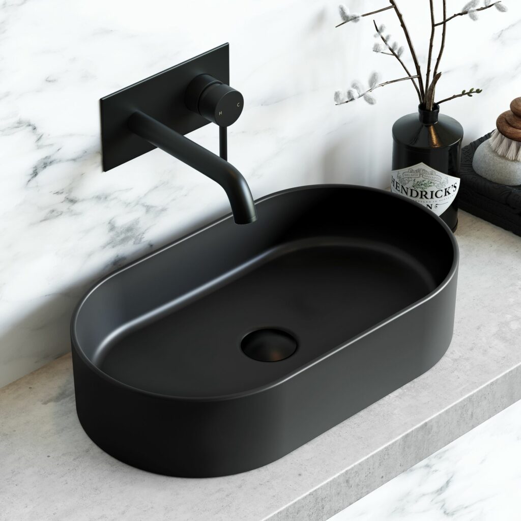 black basin with black tap and plug on grey counter top